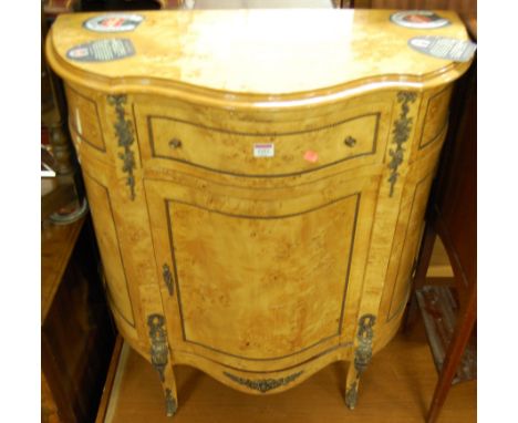 A contemporary French style birds eye maple veneered serpentine front single door side cupboard, having single upper drawer, 