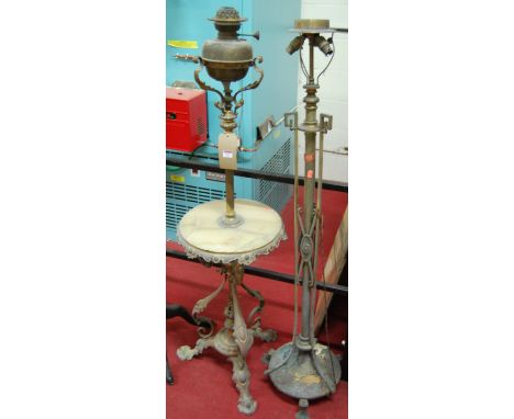 An early 20th century embossed brass and onyx inset freestanding paraffin lamp; together with an Edwardian brass three light 