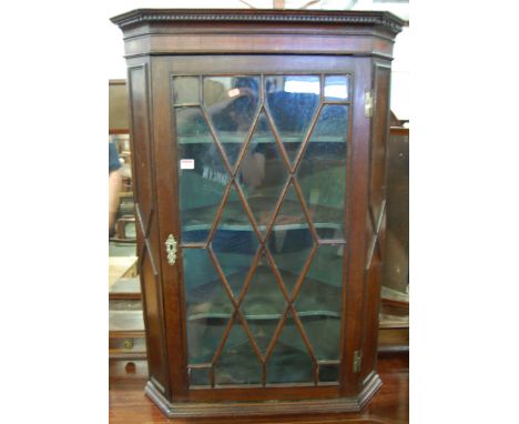 A 19th century oak and mahogany single door astragal glazed hanging corner cupboard