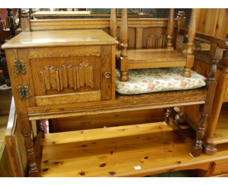 A contemporary oak linenfold panelled telephone seat, with single cupboard door, w.94cm