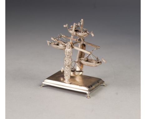 A CONTINENTAL SILVER PLATED FAIRGROUND RIDE, with four swing boats  on raised oblong base, 3 1/2" high, 2 1/2" wide 