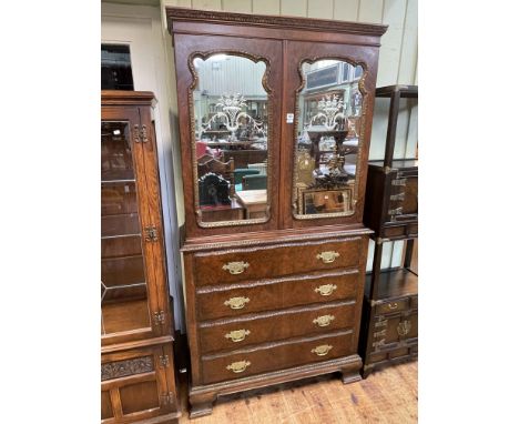 Walnut secretaire bookcase having two mirror panelled doors above a secretaire drawer with three drawers below on ogee bracke