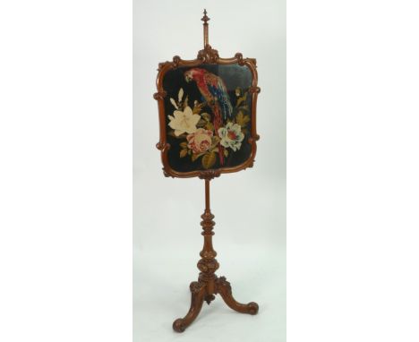 NINETEENTH CENTURY CARVED WALNUTWOOD FIRE SCREEN, the glazed oblong panel with woolwork parrot to the centre and scroll mould