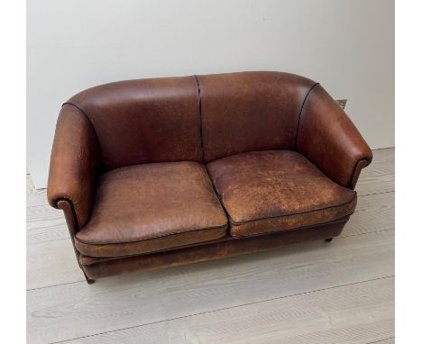 A two seater leather sofa, with tapering legs and a dark tan piping to edge (H77cm W144cm D70cm SH48cm)  Condition Report  we