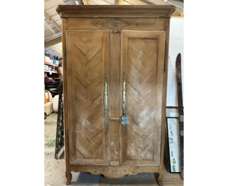 A substantial French style two door wardrobe with star marquetry inlay to crown, etched brass finger plates and carved bottom