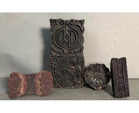 Four vintage carved wooden printing blocks in various decorative patterns 