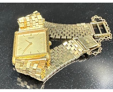 A Seiko watch on an 18ct gold bracelet with additional safety chain with an approximate weight of 56g. The watch is marked st