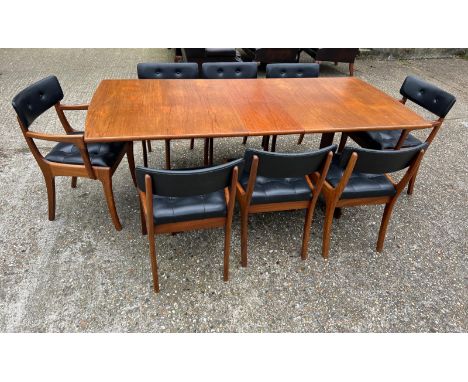 An extending teak dining table by Vanson along with the Vanson for Heals eight chairs whit black possibly leatherette seat an