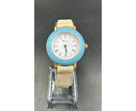 A vintage Hermes, blue bezel watch on stainless steel with white leather strap.