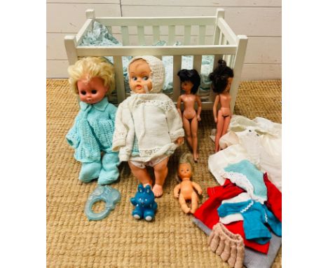 A vintage white wooden children's toy doll cot with dolls, bedding and toys  