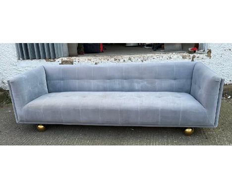 A contemporary four seater upholstered sofa in grey on brass ball feet 230cm x 86cm 