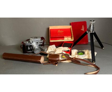 A vintage Leica camera along with a large number of accessories, including tripod