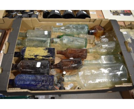 A selection of vintage advertising glass bottles in various colours and sizes