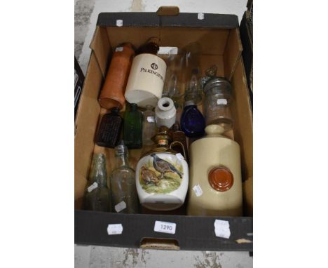 An assortment of vintage decanters and bottles including salt glazed foot warmer.