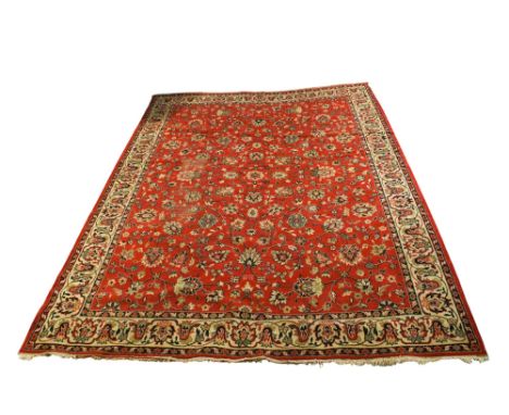 Persian style woollen carpet rug on a red ground. Multiple geometric floral borders large rectangular medallion with floral m