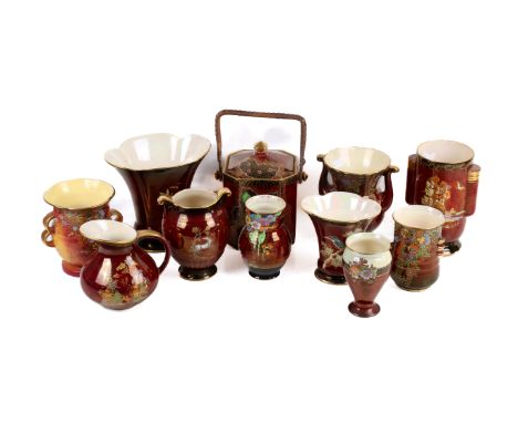 Eleven pieces of Crown Devon red lustre porcelain. Comprising two jugs, a biscuit barrel and eight vases, decorated with orie