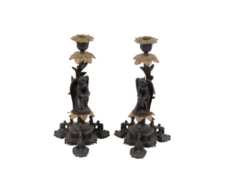 A pair of cast metal candlesticks with angels. Raised on a tripod base. H30cm