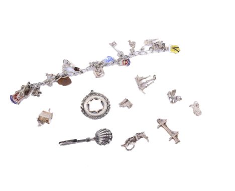 A white metal charm bracelet with charms and other silver items. The bracelet unmarked but test as silver, with 18 white meta