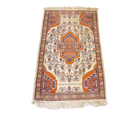 A 20th century Persian style rug. The central orange and brown medallion on a tan ground, within a floral border, 128cm x 76c
