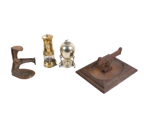 A group of vintage metal items. Comprising a boot scrape on a large rectangular base, a shoe last, egg warmer and a brass min