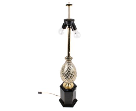 A contemporary table lamp. Featuring a brass pineapple attached to a black ceramic column with plinth base, H106cm