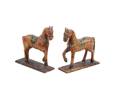 A pair of vintage Indian wooden models of horses. Heavily painted with bright colours, on rectangular bases, H15.5cm