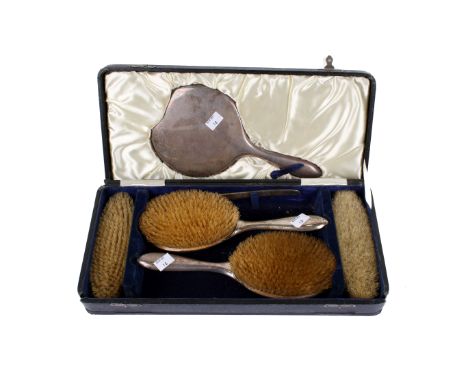 A vintage silver mounted dressing table set. Comprising four brushes, comb mount and a hand mirror, with hallmarks for S Blan