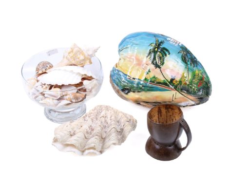 An assortment of collectables. Comprising a collection of shells, a painted coconut, a carved nut and clam shells, Max. H17cm