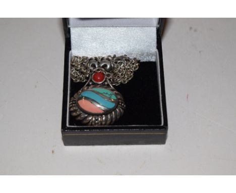A silver and enamel pendant hung to a silver chain 