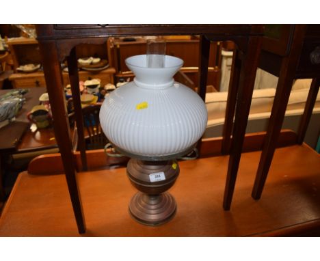 A brass oil lamp with milk glass shade