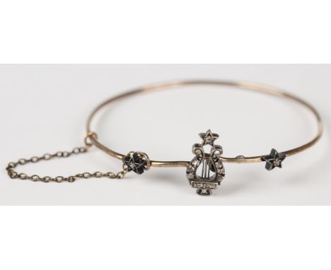 A Victorian silver set and diamond bangle, the front with a lyre motif and three stars, mounted with rose cut diamonds, fitte