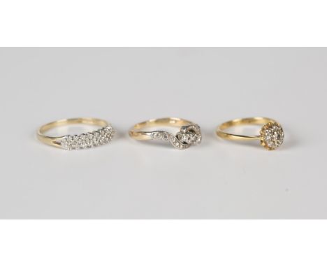 A gold and diamond three stone ring, claw set with circular cut diamonds in a twistover design, detailed '18K', ring size app