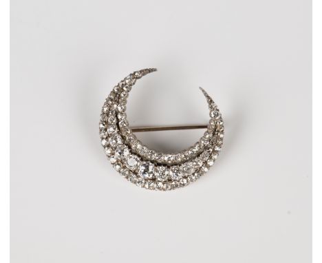 A late Victorian gold backed and silver set diamond brooch, designed as a crescent, mounted with three rows of graduated cush