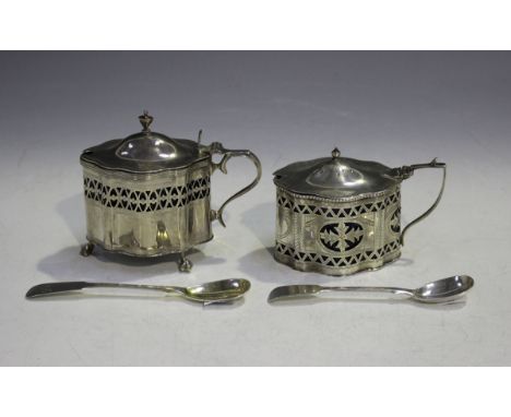 An Edwardian silver oval mustard with domed hinged lid and urn finial above serpentine sides and pierced decoration, on claw 