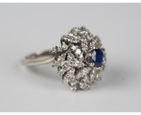 A 14ct gold, sapphire and diamond cluster ring, claw set with the oval cut sapphire within a surround of circular cut diamond