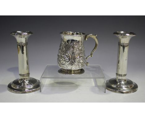 A George III silver tankard of baluster form with foliate capped scroll handle, the body later chased with flowers and scroll