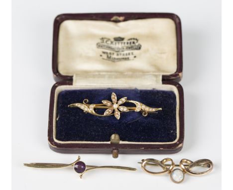 A gold bar brooch, collet set with a circular cut amethyst in a twist design, detailed '15ct', width 5.4cm, and a gold and se