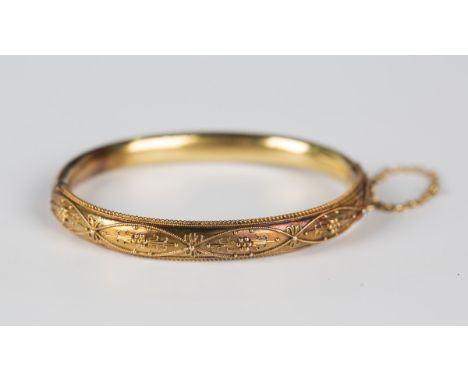 A gold oval hinged bangle in the classical taste, the front with applied bead and wirework decoration, on a snap clasp, fitte