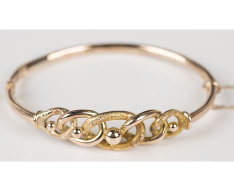 A 9ct gold oval hinged bangle, the front of graduated curblink design with engraved and beaded decoration, on a snap clasp, B