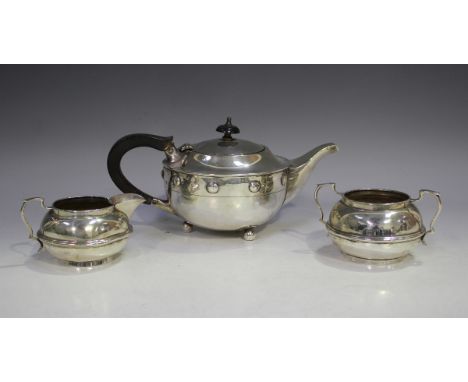 A George IV silver teapot of squat circular form, decorated in relief with circular cabochons, raised on ball feet, Birmingha