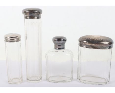 Four early 20th century silver and glass dressing bottles, including Mappin &amp; Webb, two with engine turned lids, tallest 