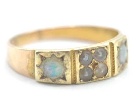 A 19th Century Victorian 15ct gold ring being set with four seed pearls flanked by two opal cabochons. Hallmarked Birmingham 