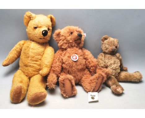 A group of three vintage late 20th century teddy bears. A brown Steiff teddy bear with tag to the left ear and glass eyes alo