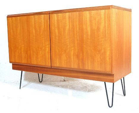 A vintage mid century Danish inspired teak wood sideboard having double door cupboard with lozenges handles raised on black m