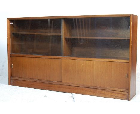 A vintage mid century Gibbs oak display cabinet having glass sliding doors atop and wooden sliding doors underneath with Gibb