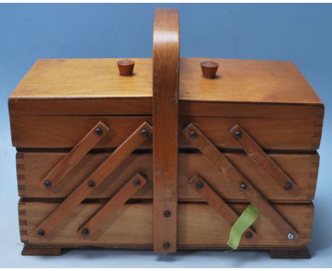 A vintage mid century metamorphic sewing box having a hinged lid, with three compartments &nbsp;and dome handle to the top ra