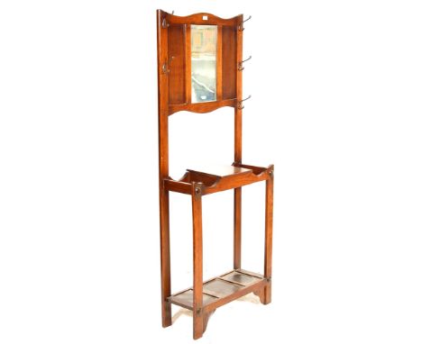 An early 20th Century Edwardian antique oak Arts and Crafts style hall stand having a wooden panel topped with a central mirr