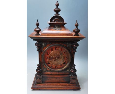 A 19th century Victorian American walnut mantle clock having a dome top with three turned finial, brass green man face decora