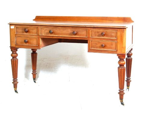 A 19th Century Victorian mahogany writing table desk having a gallery back with five drawers assembled around a central knee 