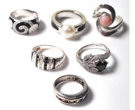 A group of six ladies silver rings to include a black and white enamelled ring set with white stones, a ring channel set with